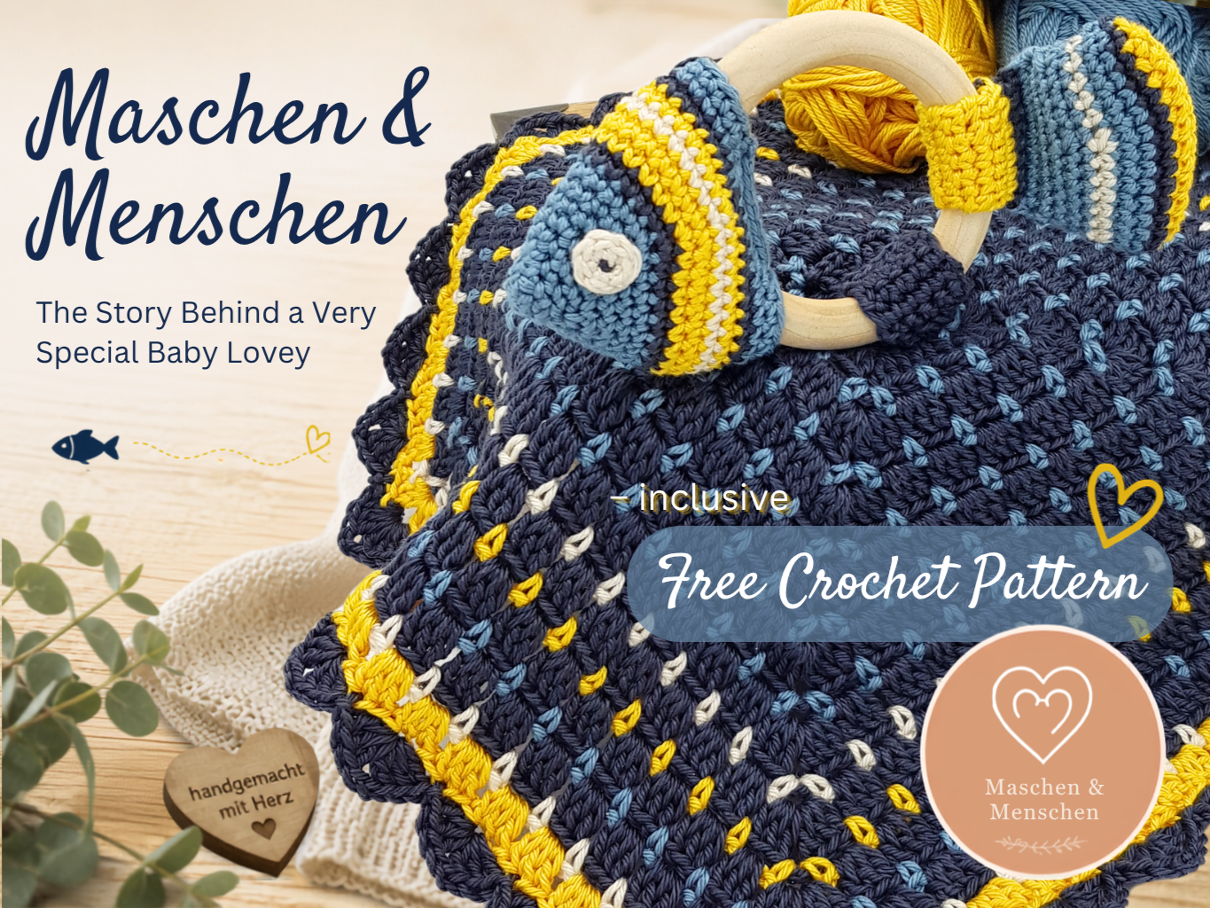 Crocheted baby lovey blanket in navy, blue, and yellow with wooden ring and heart badge.